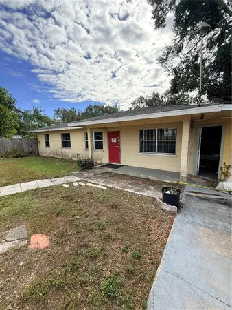 a view of a house with backyard and sitting area