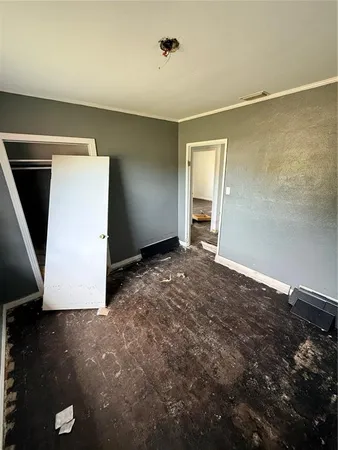 a view of an empty room with closet and a window