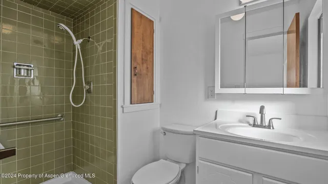 a bathroom with a granite countertop sink and a toilet