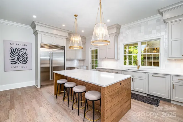 a kitchen with stainless steel appliances granite countertop a sink a stove and a refrigerator