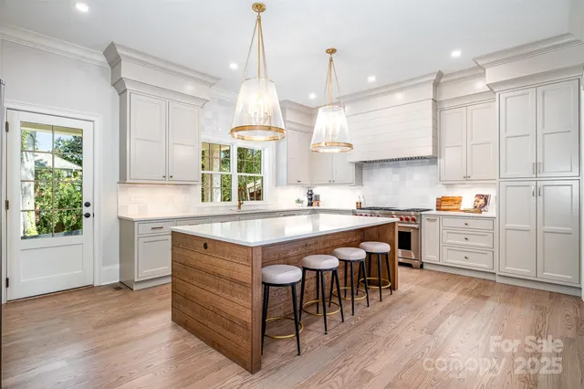 a kitchen with kitchen island granite countertop a stove a sink a center island and wooden floor