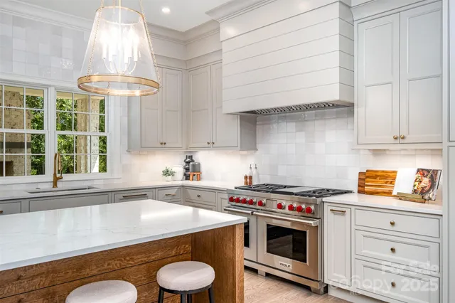 a kitchen with stainless steel appliances granite countertop a sink a stove and a wooden floors