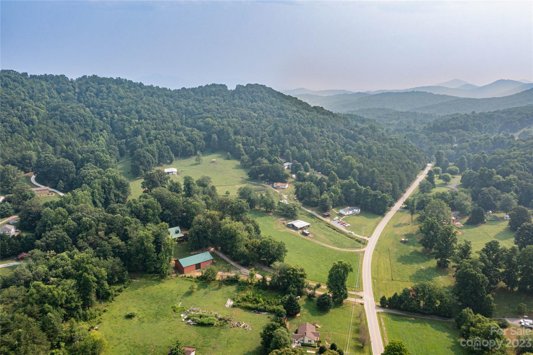 752 Upper Glady Fork Road Candler, NC 28715 - Photo 28 of 38 an aerial view of green landscape with trees houses and mountain view