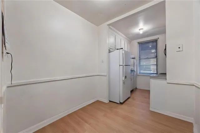 a view of empty room with wooden floor and cabinet