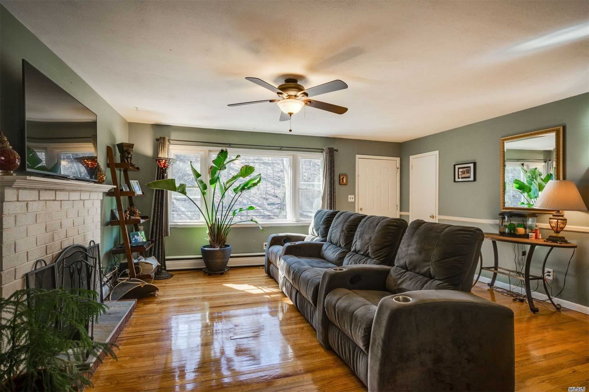 a living room with furniture a ceiling fan and a flat screen tv