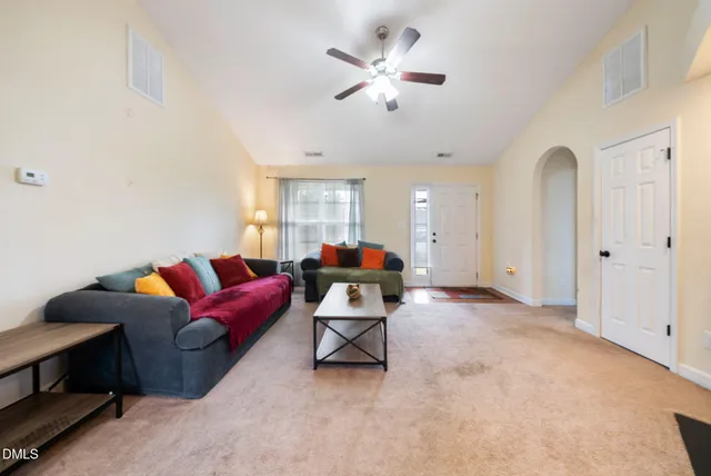 a living room with furniture and a ceiling fan