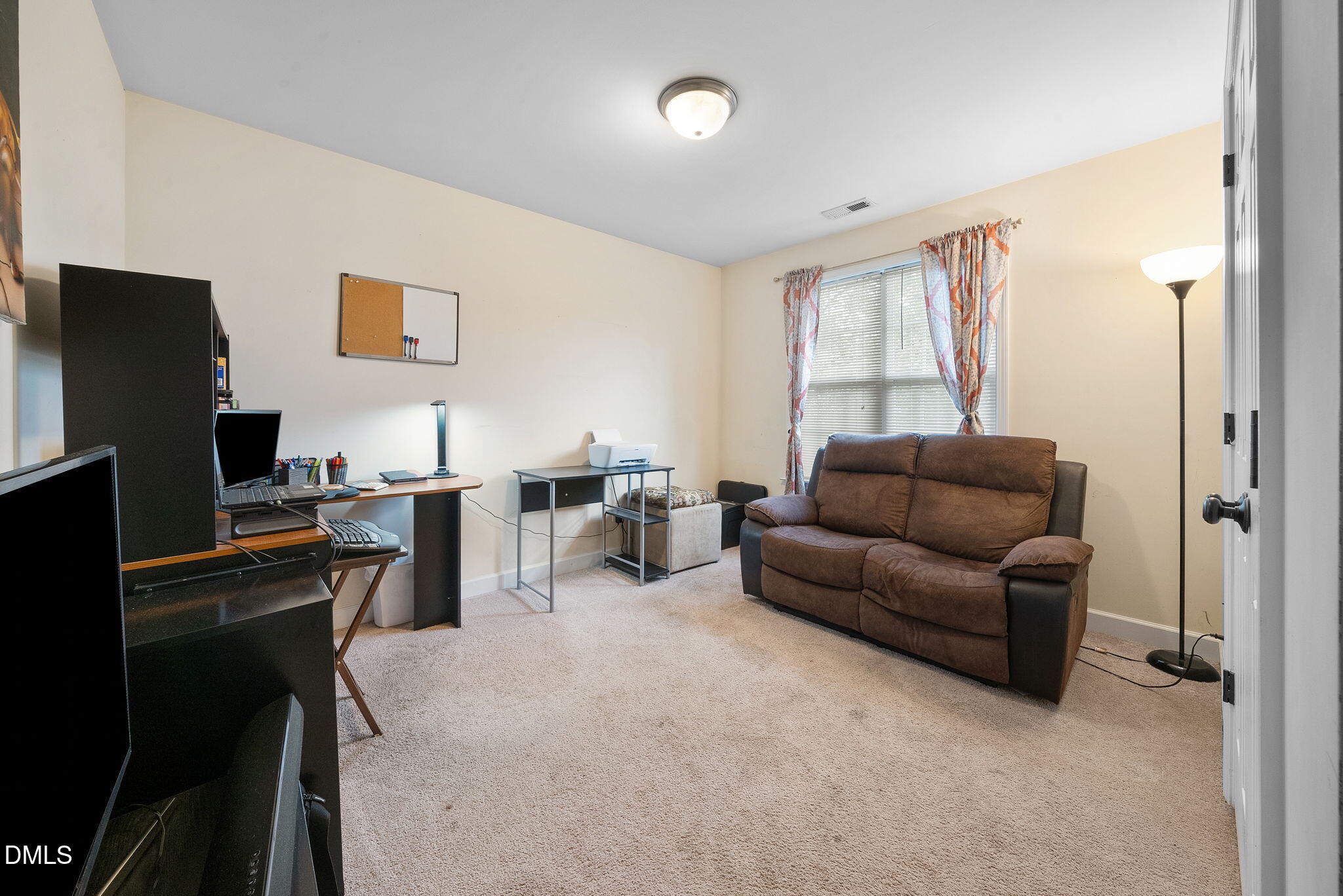 25 Lawrence Court Smithfield, NC 27577 - Photo 25 of 41 a living room with furniture a desk and a flat screen tv