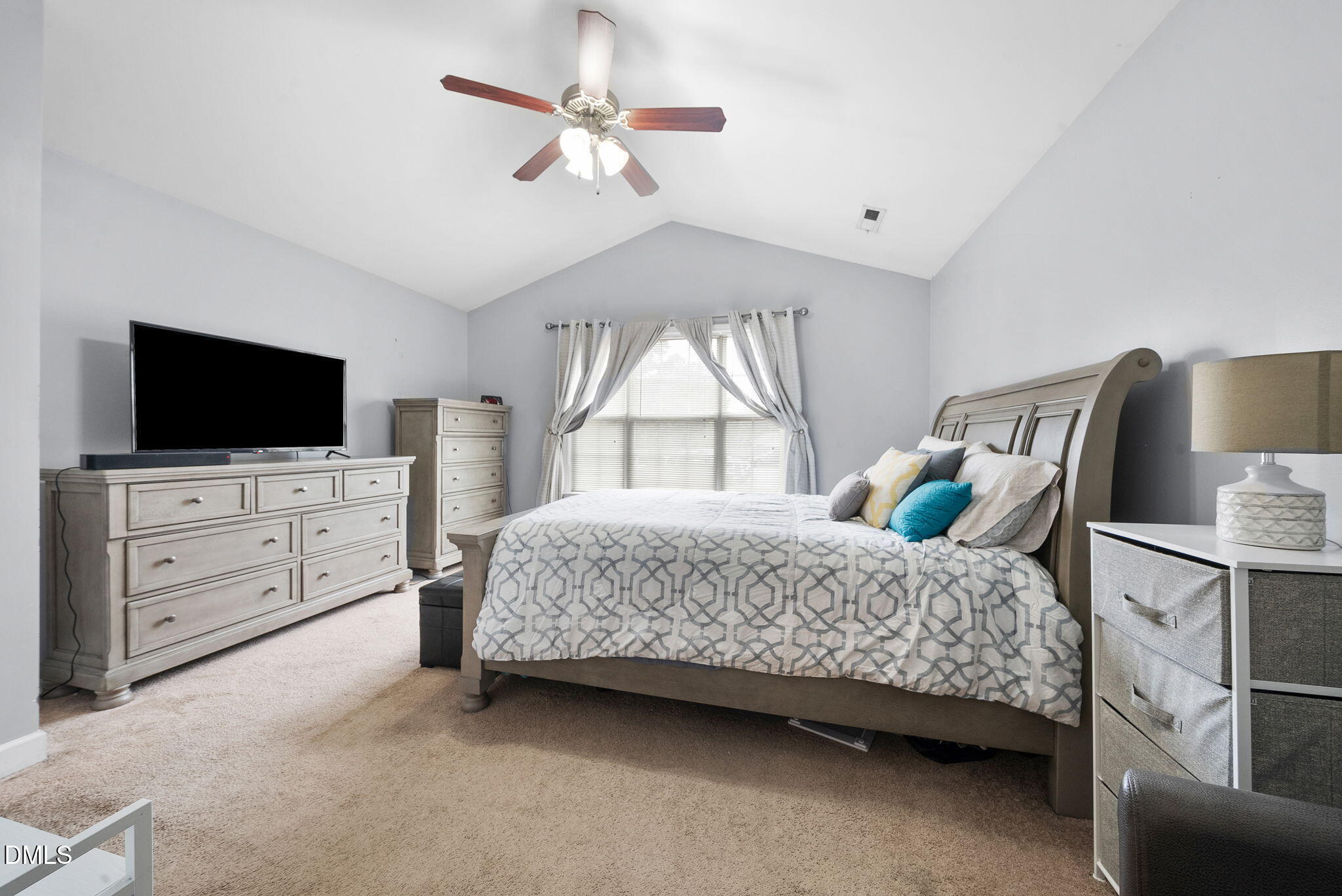 25 Lawrence Court Smithfield, NC 27577 - Photo 29 of 41 a bedroom with a bed a chandelier and a flat tv screen on dresser