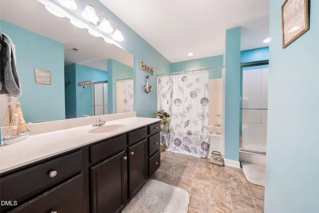 a spacious bathroom with a shower a sink and a mirror