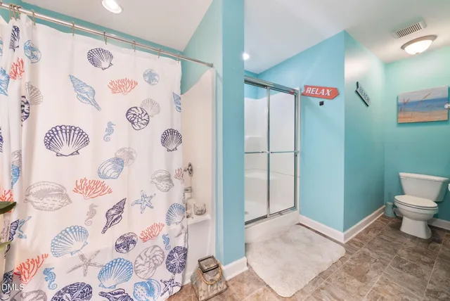 a bathroom with a toilet and a shower curtain