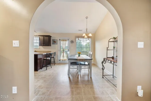a living room with furniture a chandelier and a flat screen tv
