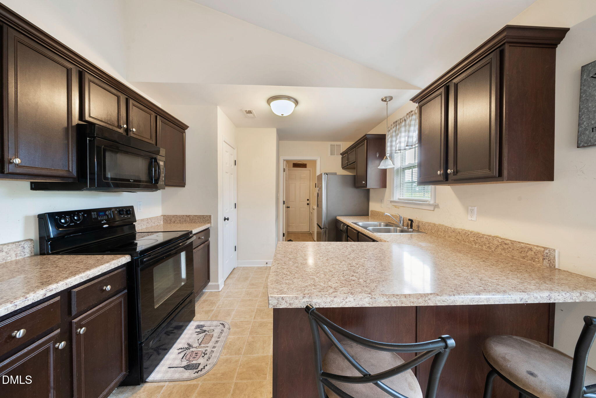 25 Lawrence Court Smithfield, NC 27577 - Photo 9 of 41 a kitchen with stainless steel appliances granite countertop a sink a stove a refrigerator cabinets and chairs
