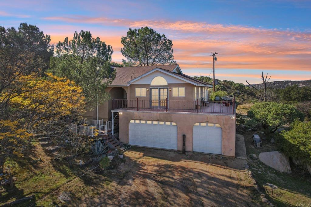 a view of a white house with a yard and large tree