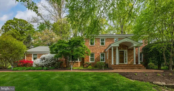 a front view of a house with a garden and trees