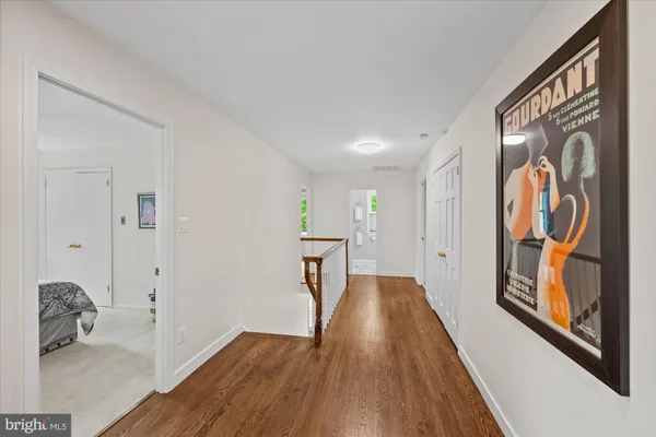a view of hallway with furniture and wooden floor