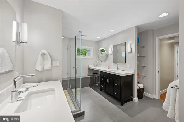 a bathroom with a double vanity sink mirror and window