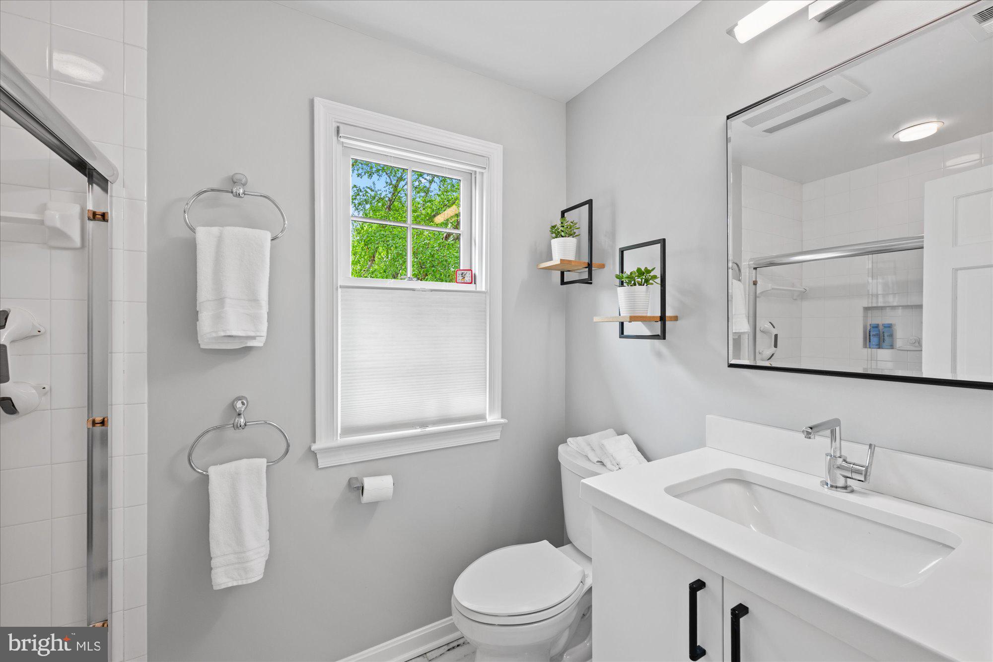 7908 Foxhound Road McLean, VA 22102 - Photo 38 of 48 a bathroom with a toilet a sink a mirror and a window