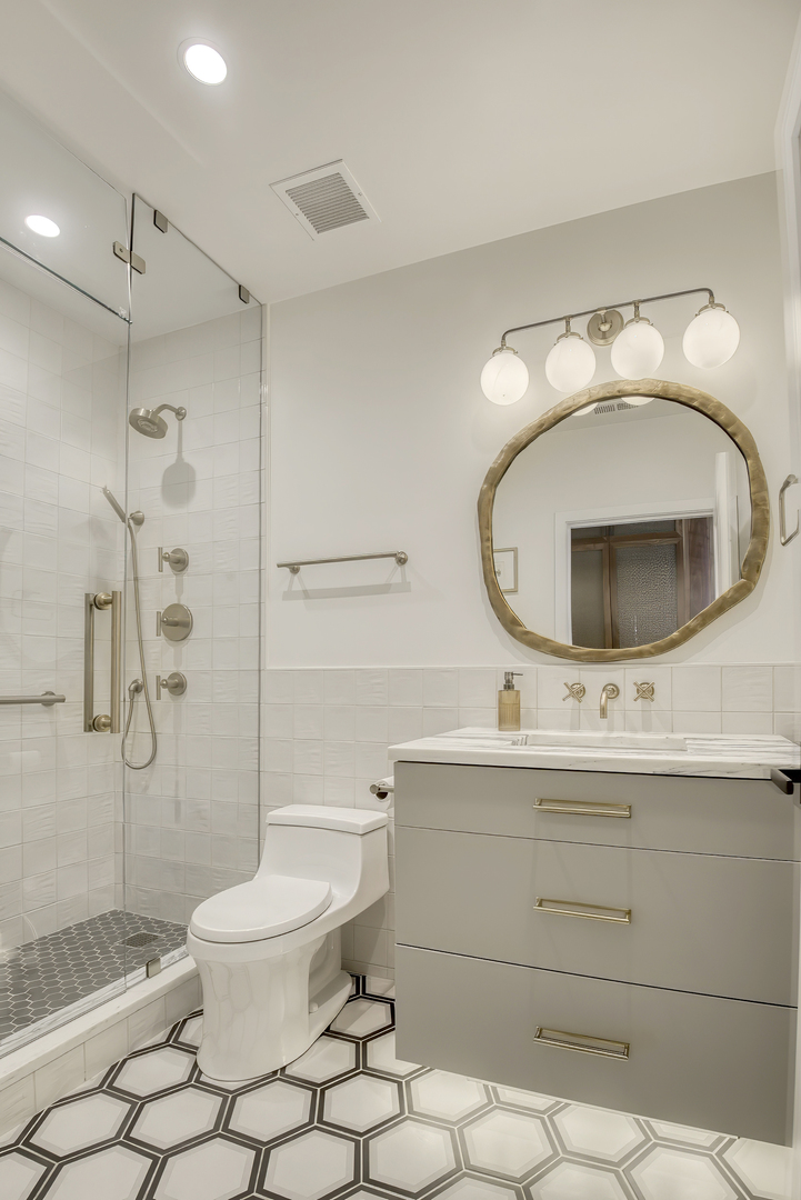 910 West Madison Street, Unit 904E Chicago, IL 60607 - Photo 46 of 56 a bathroom with a sink mirror vanity and toilet