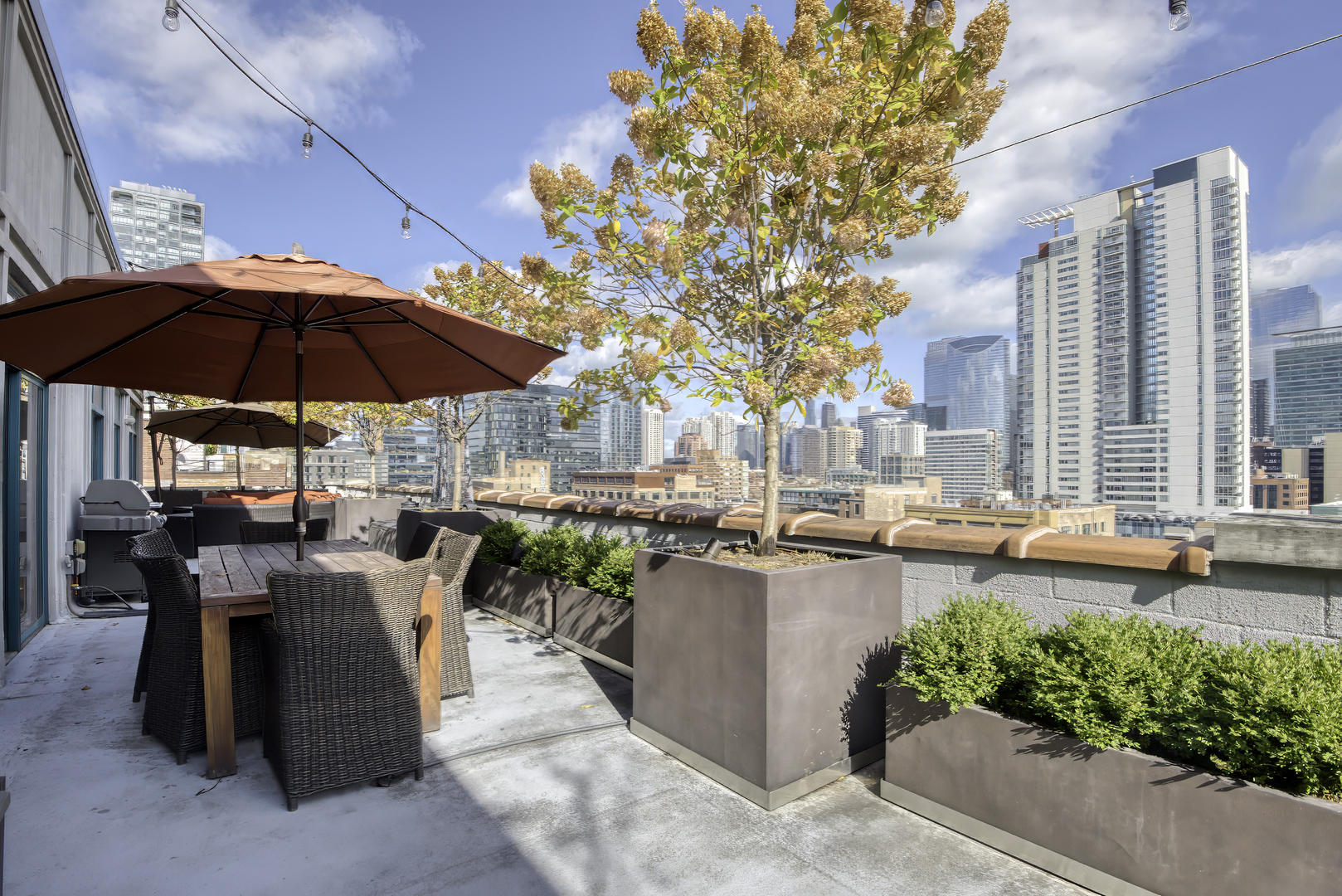 910 West Madison Street, Unit 904E Chicago, IL 60607 - Photo 53 of 56 a view of a patio with chairs and table under an umbrella