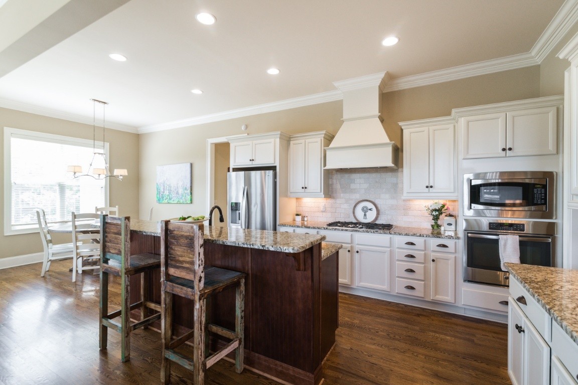 192 Barlow Drive Franklin, TN 37064 - Photo 10 of 36 a kitchen with stainless steel appliances granite countertop a stove top oven a sink a dining table and chairs with wooden floor