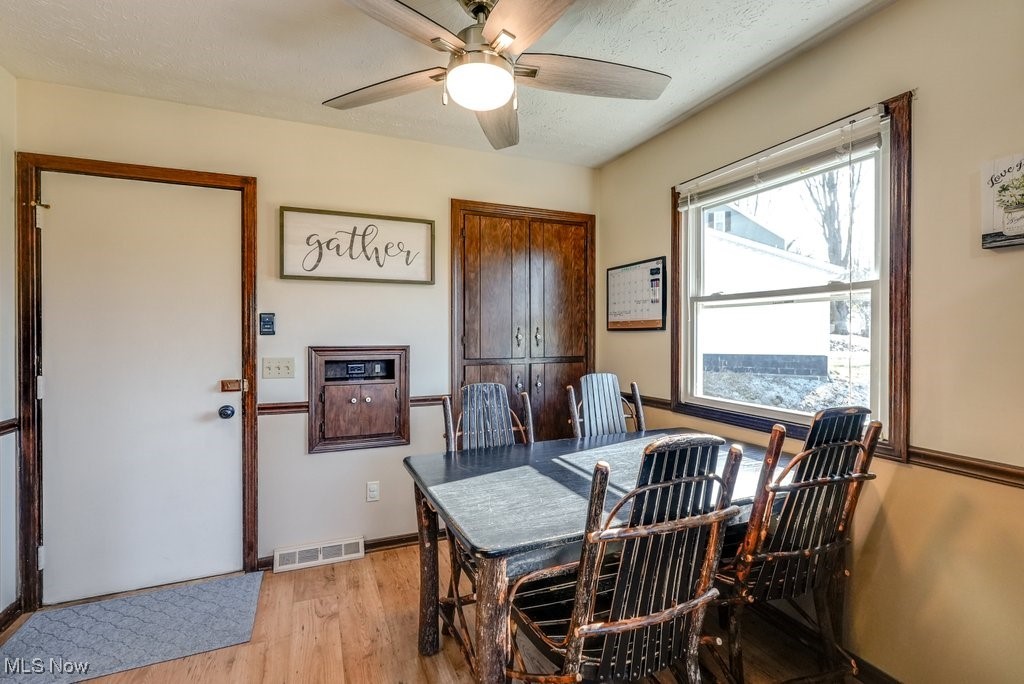 1157 Bass Circle Northwest Canton, OH 44708 - Photo 12 of 31 Dining room with a ceiling fan, baseboards, visible vents, a textured ceiling, and light wood-type flooring