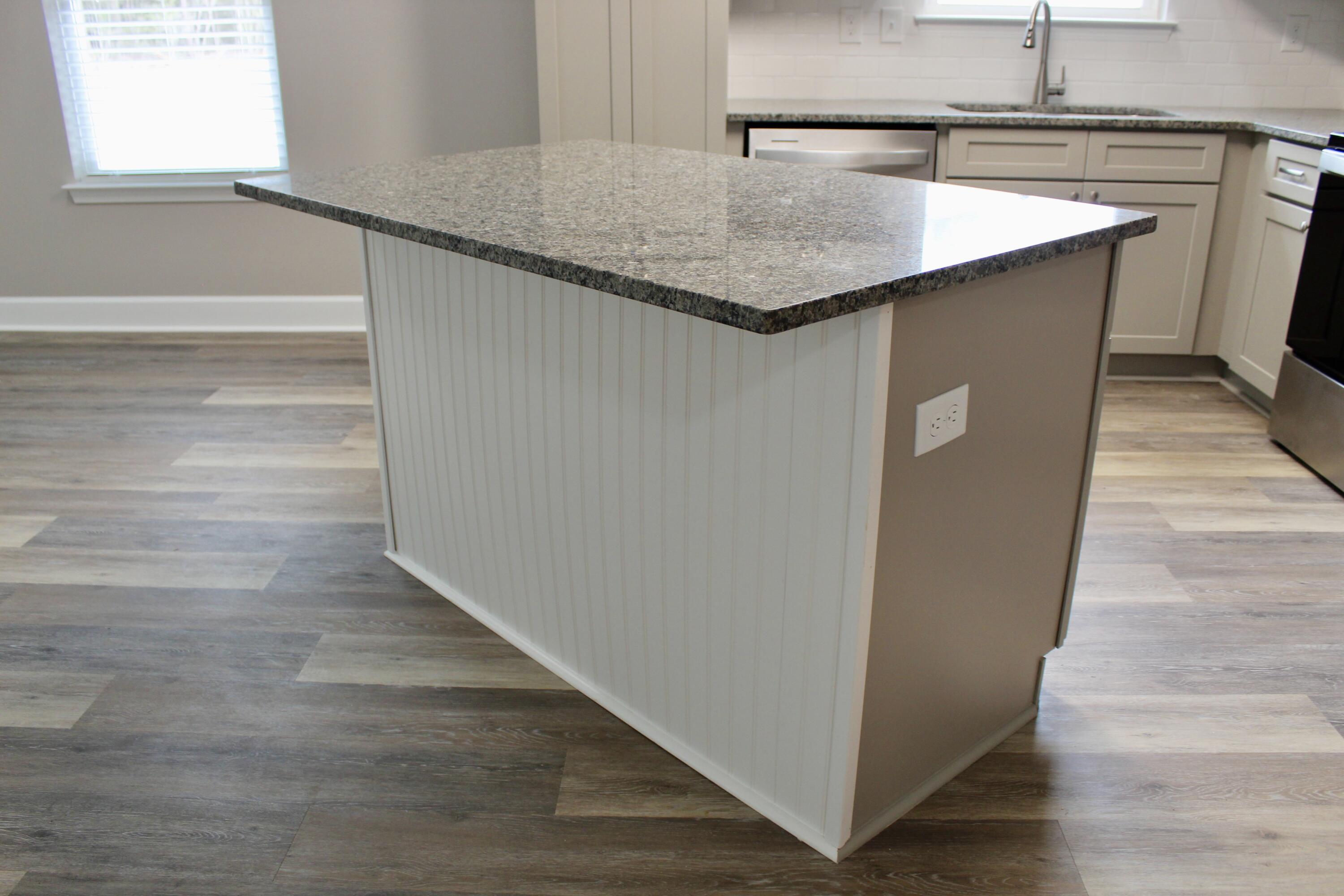 4639 Falcon Way Crestview, FL 32539 - Photo 17 of 40 a kitchen with kitchen island a counter top and a wooden floor
