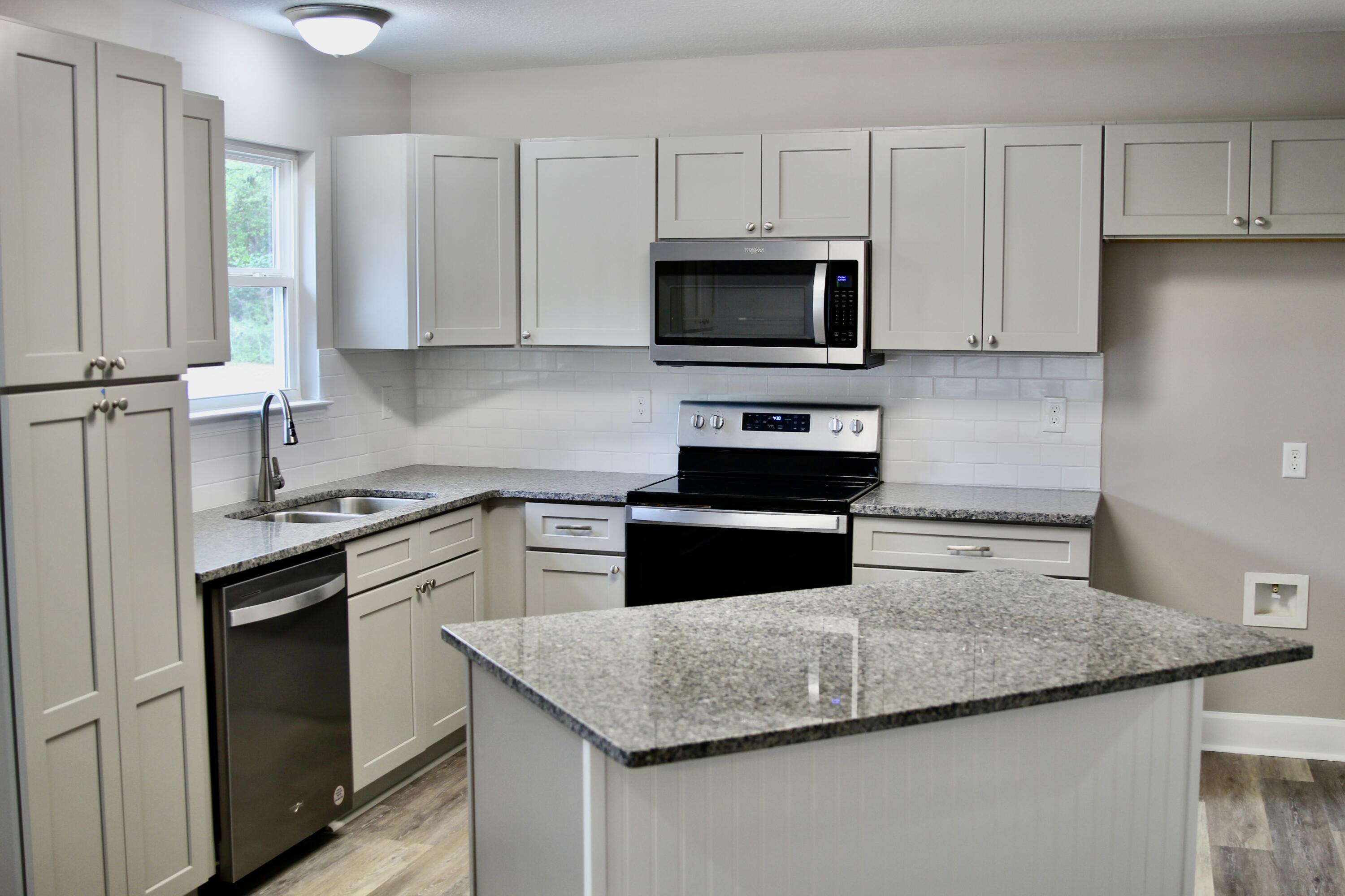 4639 Falcon Way Crestview, FL 32539 - Photo 20 of 40 a kitchen with granite countertop white cabinets and stainless steel appliances