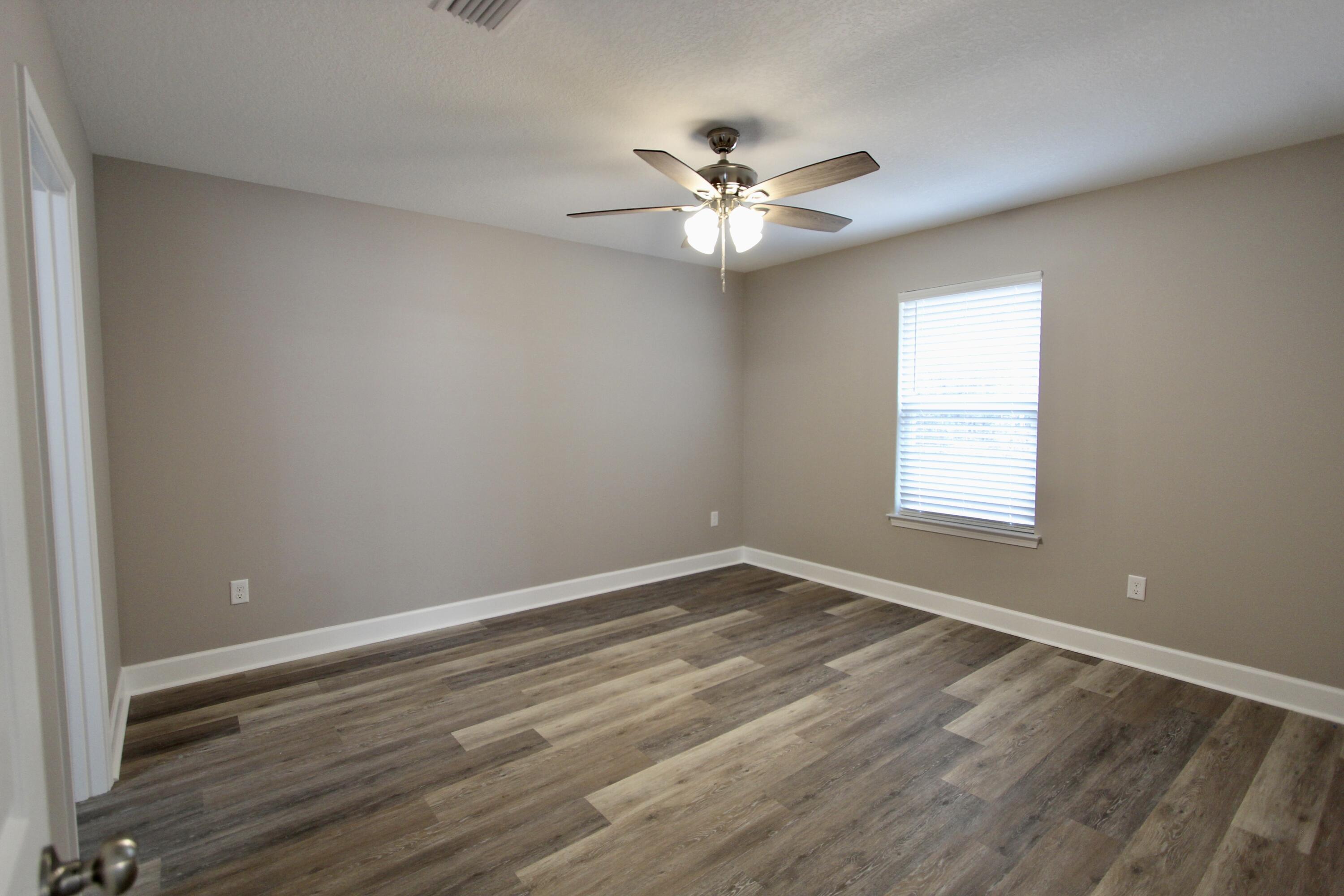 4639 Falcon Way Crestview, FL 32539 - Photo 25 of 40 a view of an empty room with wooden floor and a window