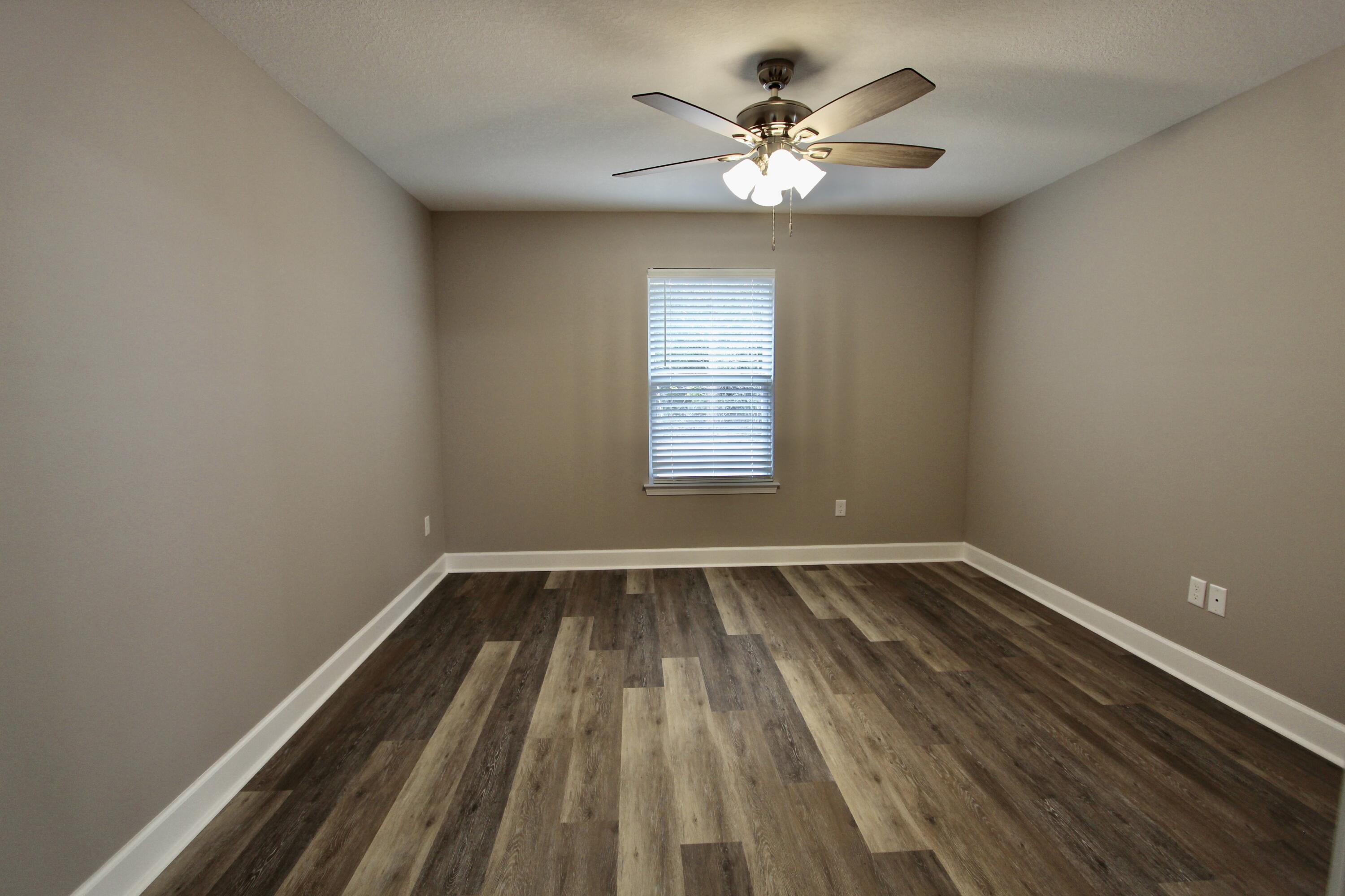 4639 Falcon Way Crestview, FL 32539 - Photo 26 of 40 a view of an empty room with wooden floor and a window