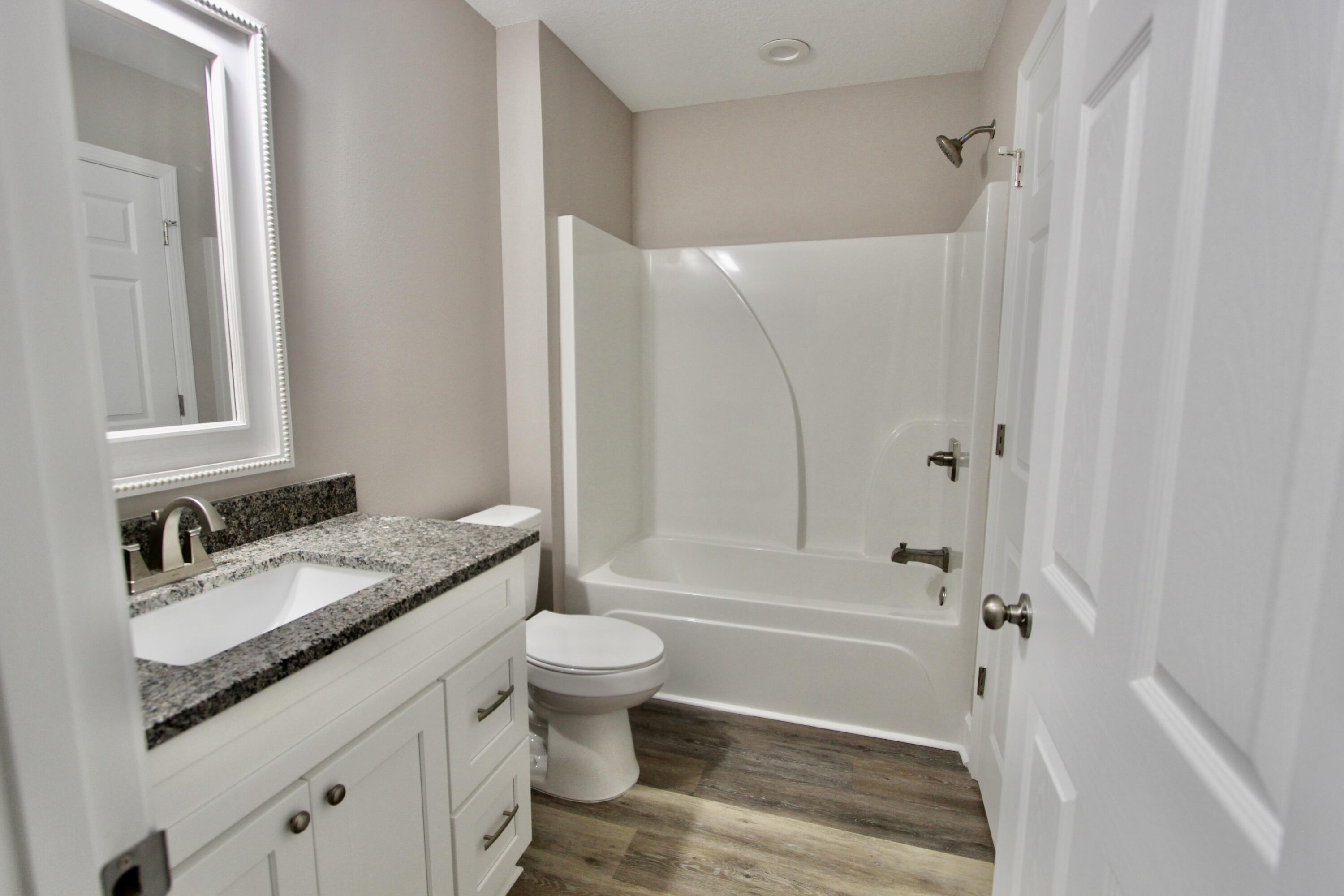 4639 Falcon Way Crestview, FL 32539 - Photo 30 of 40 a bathroom with a granite countertop sink toilet and shower