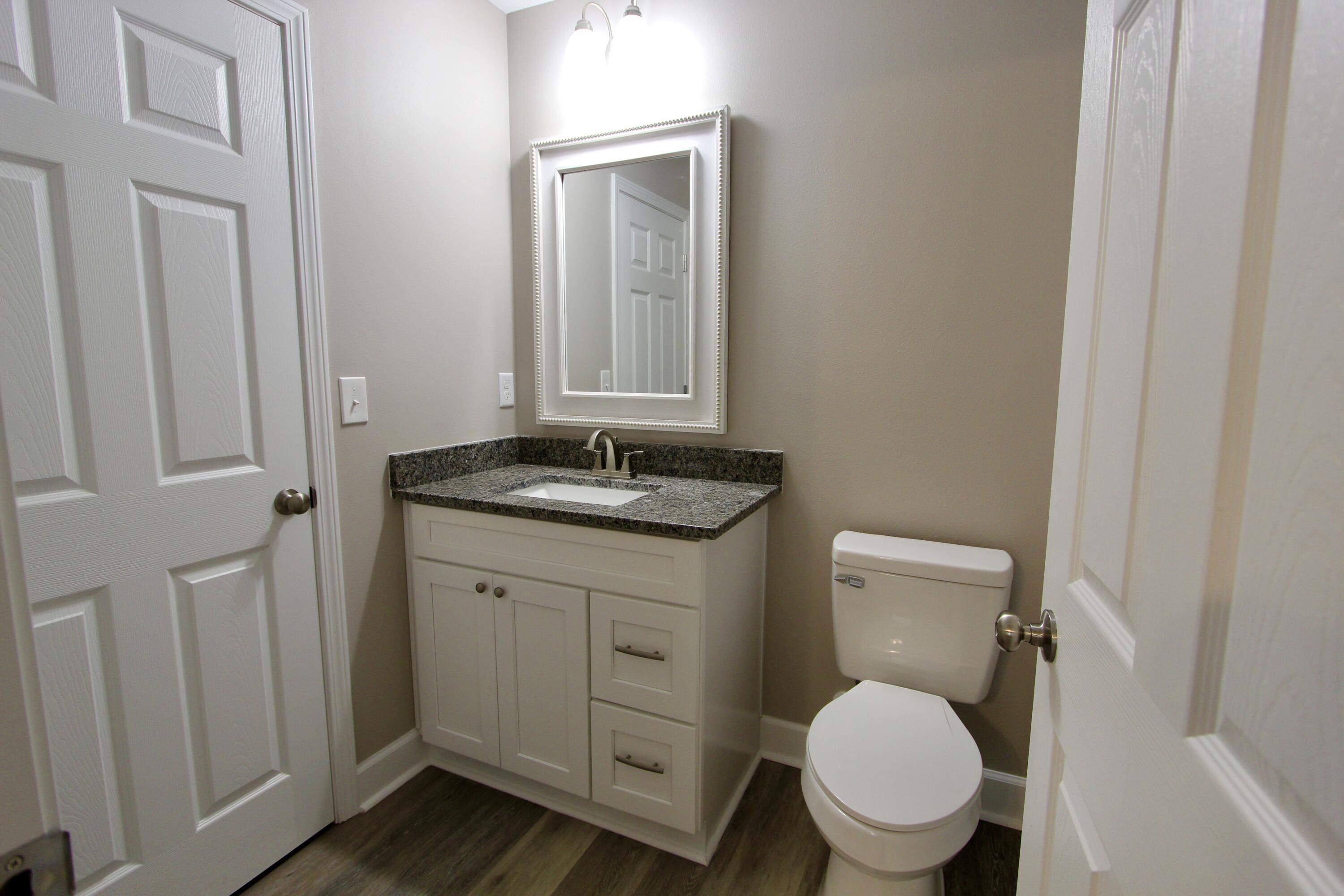 4639 Falcon Way Crestview, FL 32539 - Photo 31 of 40 a bathroom with a granite countertop toilet sink and mirror