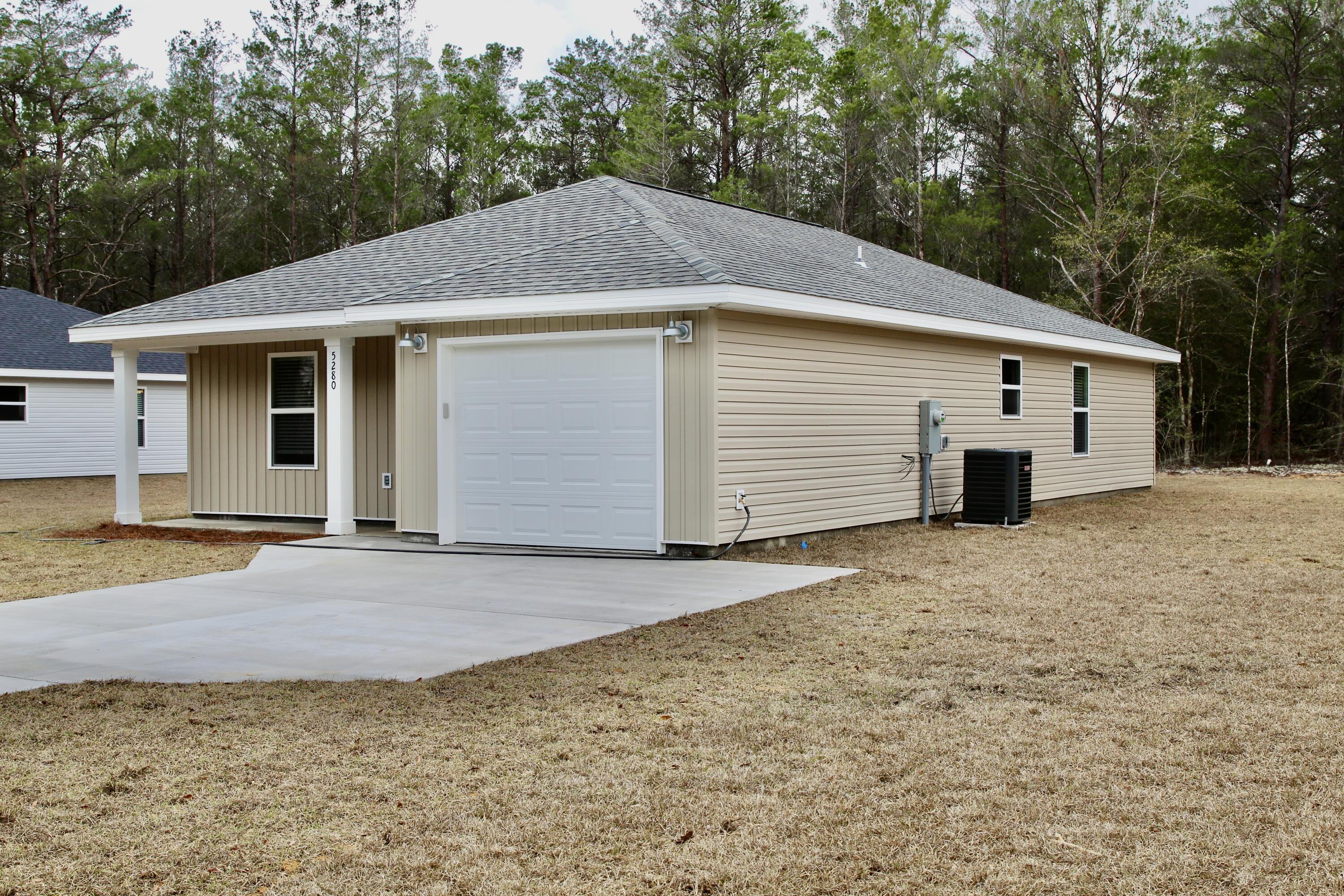 4639 Falcon Way Crestview, FL 32539 - Photo 6 of 40 a front view of a house with a yard and garage