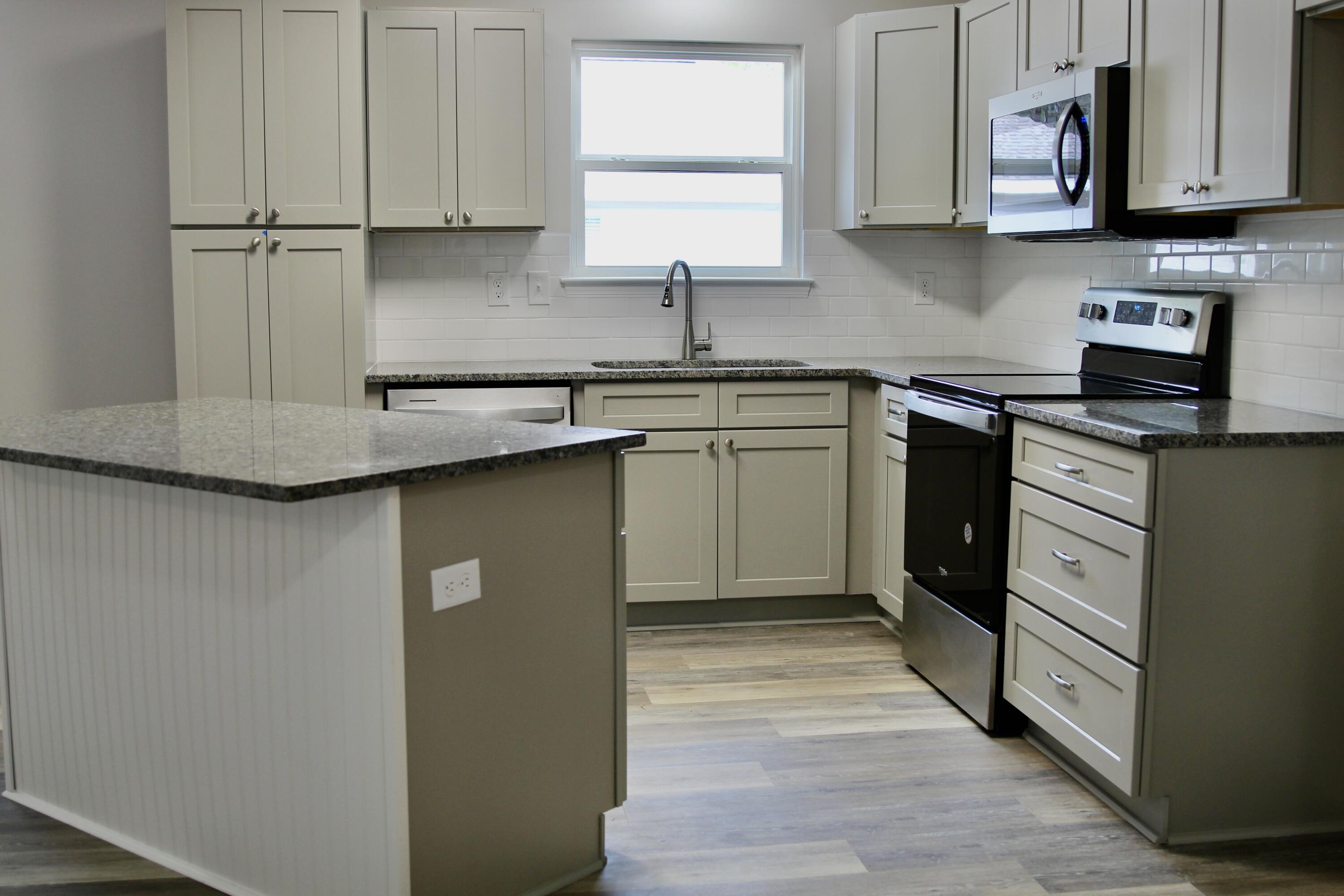 4639 Falcon Way Crestview, FL 32539 - Photo 8 of 40 a kitchen with stainless steel appliances granite countertop a sink a stove and cabinets