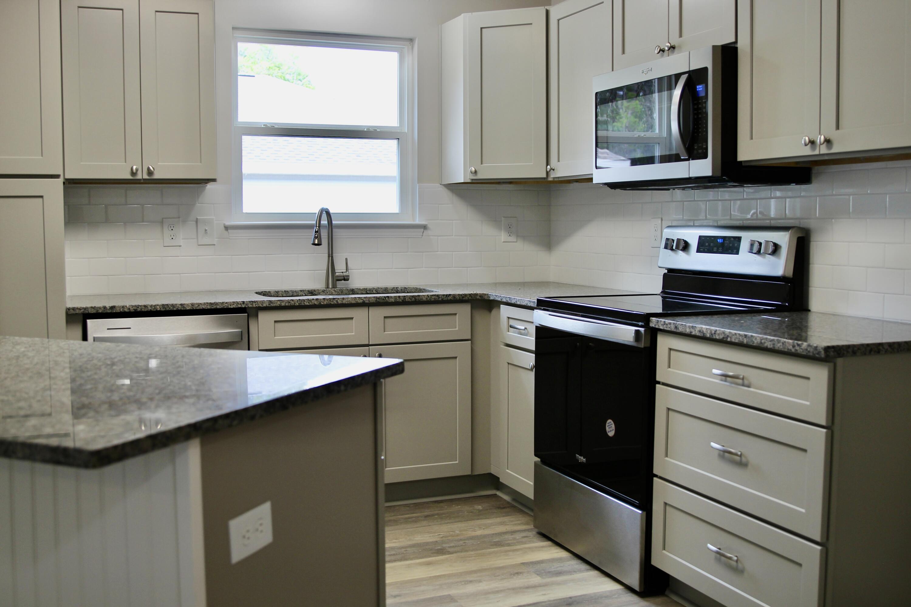 4639 Falcon Way Crestview, FL 32539 - Photo 10 of 40 a kitchen with stainless steel appliances granite countertop a sink stove and microwave
