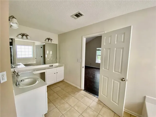 a bathroom with a granite countertop sink a mirror and a bathtub