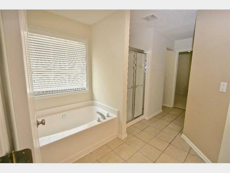 9020 Friarbridge Drive Suwanee, GA 30024 - Photo 41 of 48 a bathroom with a bathtub and a shower