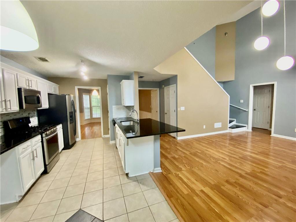 9020 Friarbridge Drive Suwanee, GA 30024 - Photo 5 of 48 a large space with a large counter top space a sink a window and stainless steel appliances