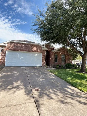 a front view of a house with a yard and a garage