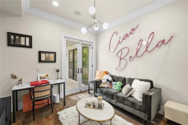 a living room with stainless steel appliances furniture a rug and a kitchen view
