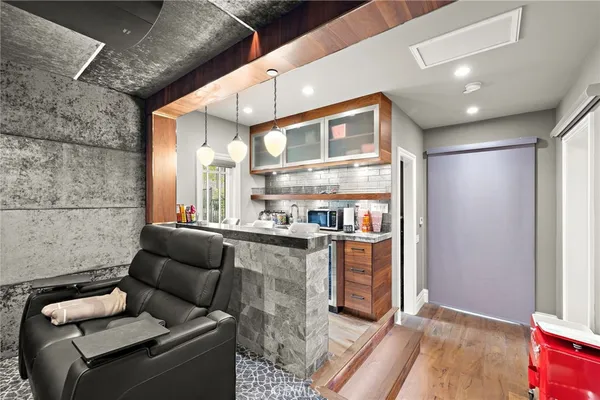 a living room with furniture flat screen tv and kitchen view