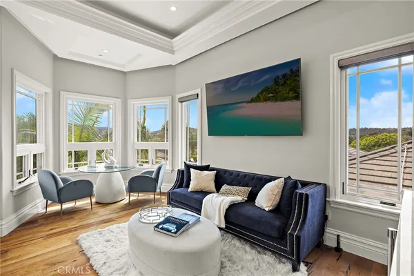 a living room with furniture a chandelier and a flat screen tv