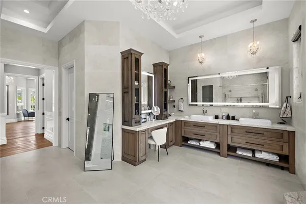 a large white kitchen with a stove a sink dishwasher and a dining table with wooden floor