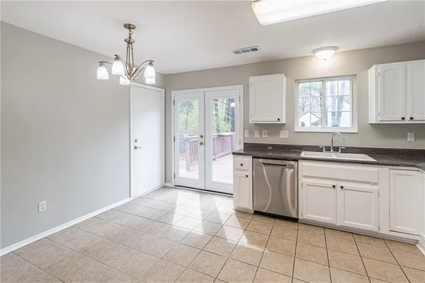 a large kitchen with cabinets a sink a window and stainless steel appliances