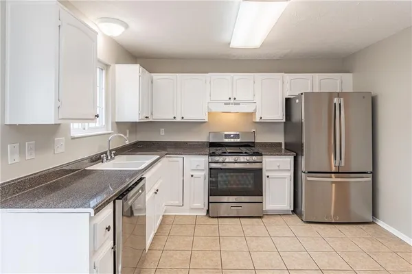 a kitchen with a refrigerator sink and cabinets