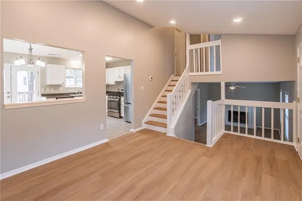 an empty room with wooden floor and staircase