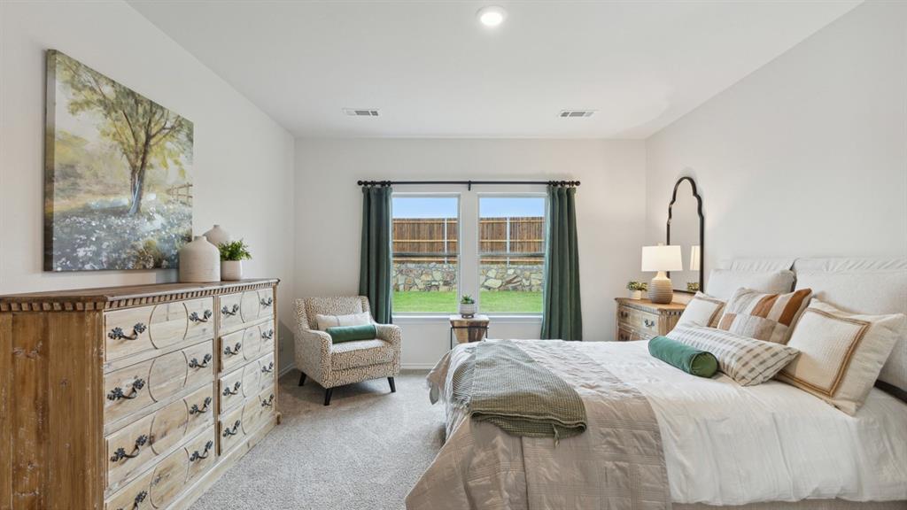 140 Pheasant Run Road Terrell, TX 75160 - Photo 18 of 26 Light-colored walls defining the bedroom space, with two windows overlooking a fenced backyard