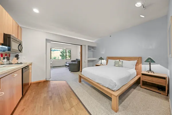 a bedroom with a bed and a flat tv screen on the dresser