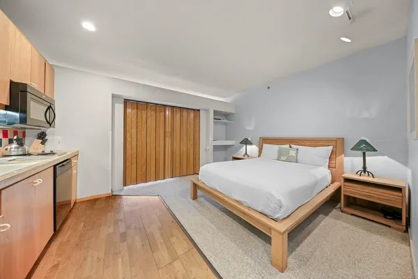 a bedroom with a bed and a flat tv screen on wall