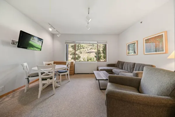 a living room with furniture a large window and a flat screen tv