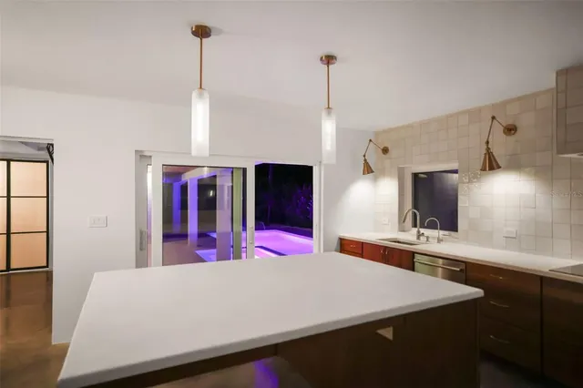 a kitchen with stainless steel appliances a stove a sink and a refrigerator with wooden floor